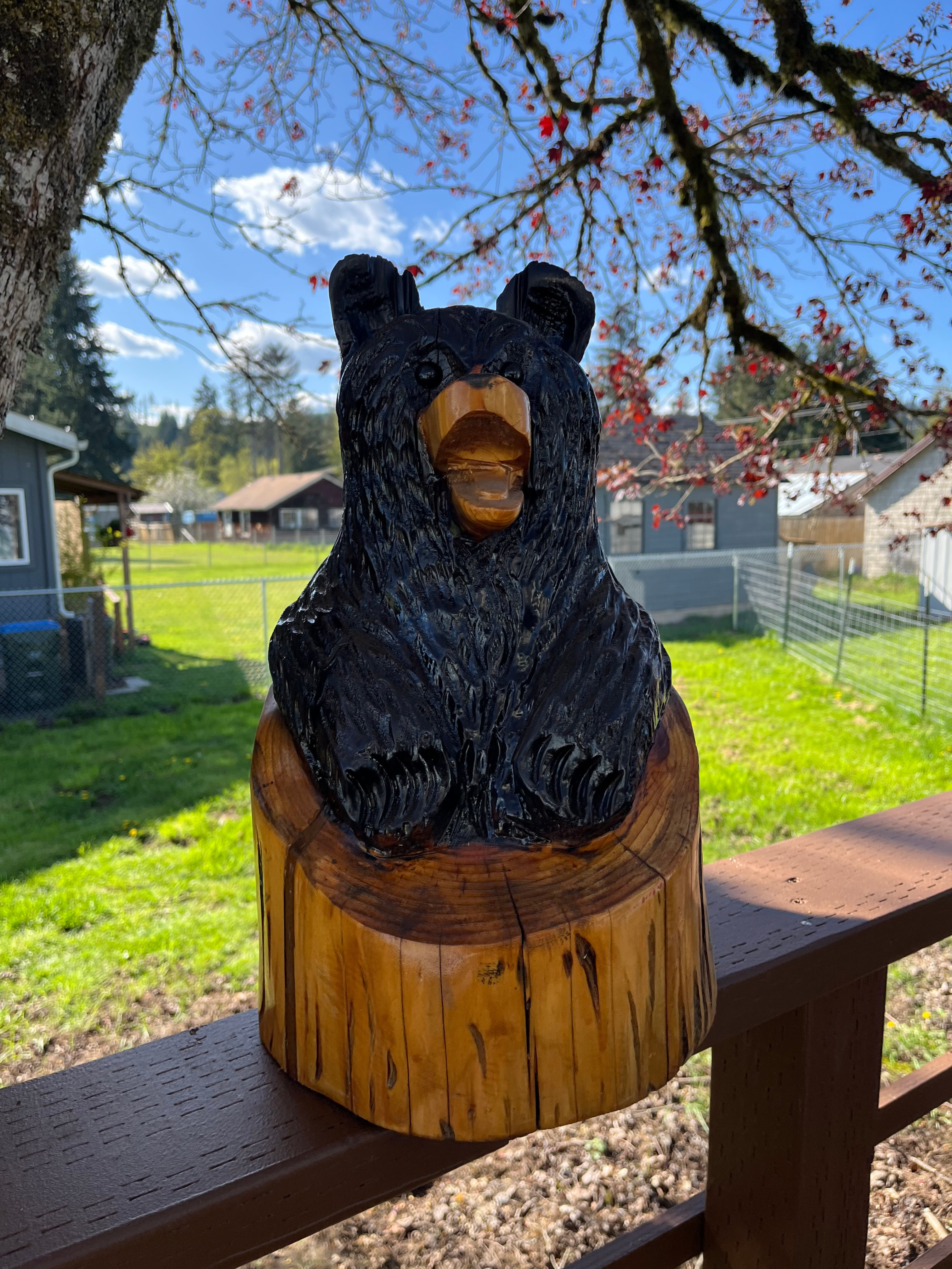 Black bear carved from a log, sitting on a wood stump base